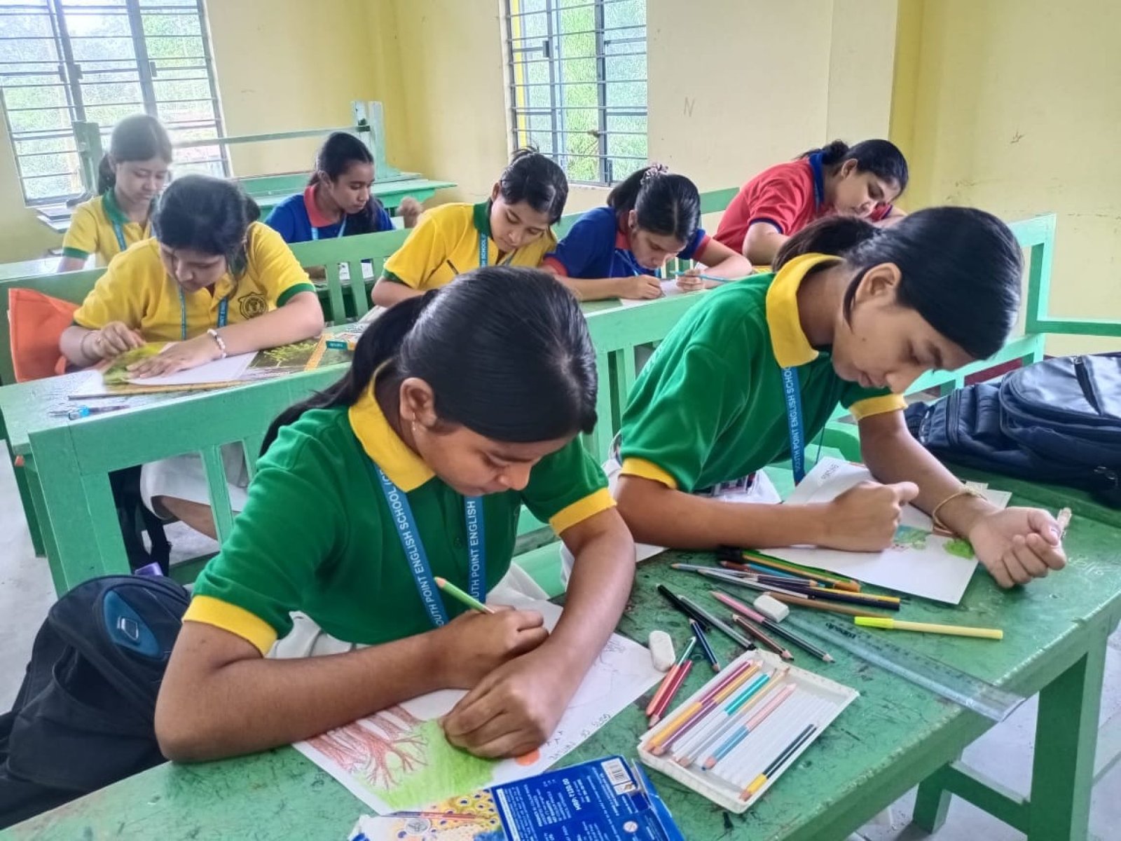 Students drawing at their desks during an art lesson